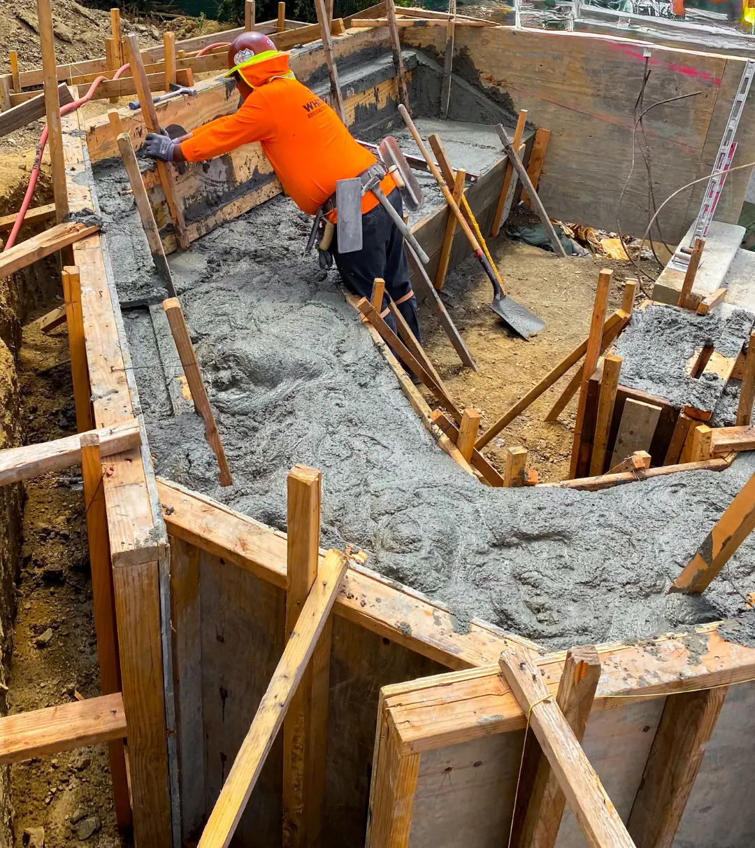 Crew member placing concrete into the bench formwork