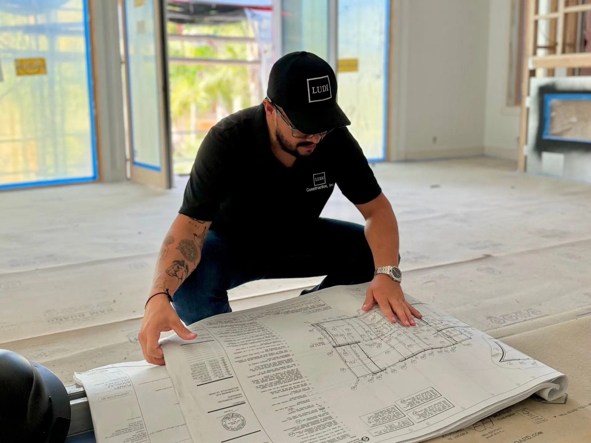 Ludi team member reviewing plans inside a residence under construction